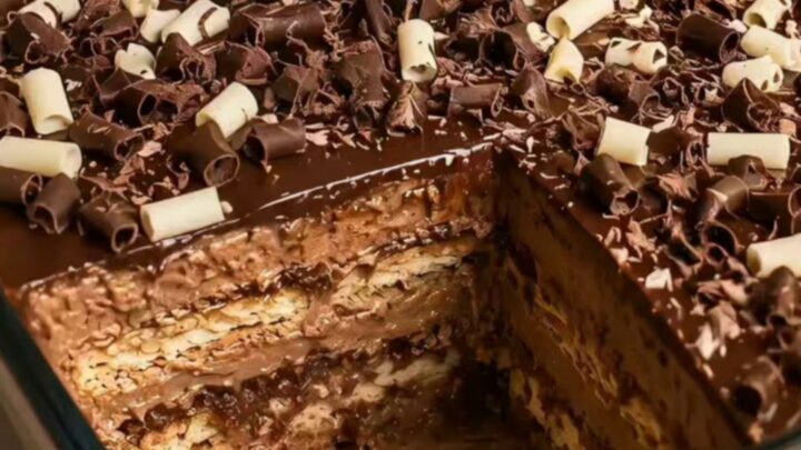 A tall, beautiful slice of chocolate pavê on a white plate showing distinct layers.