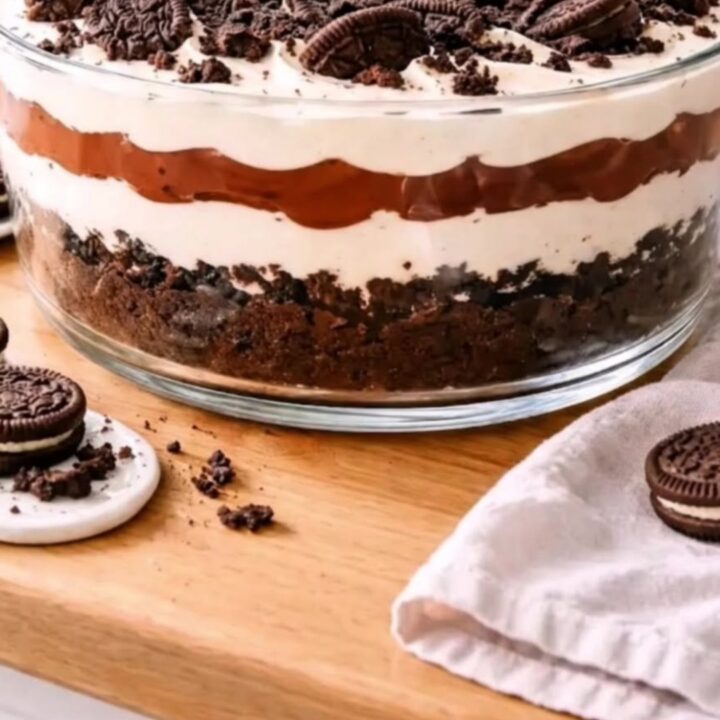 A beautiful layered Oreo chocolate cream trifle in a large glass bowl, showing distinct layers of cookies, pudding