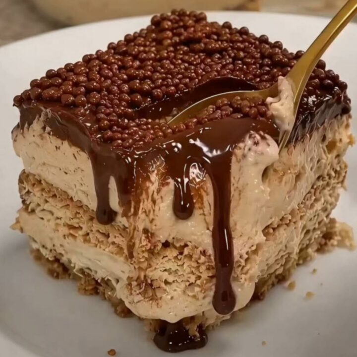 A square slice of chocolate biscuit icebox cake on a white plate, showing distinct layers.