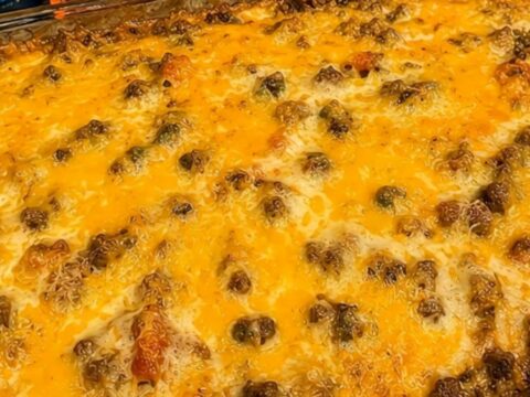 A golden-brown cheesy taco casserole in a glass baking dish sitting on a kitchen counter.