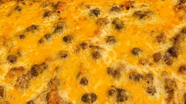 A golden-brown cheesy taco casserole in a glass baking dish sitting on a kitchen counter.