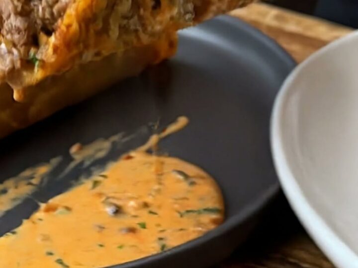 A golden, crispy cheese-shell taco filled with seasoned ground beef and topped with creamy orange sauce.