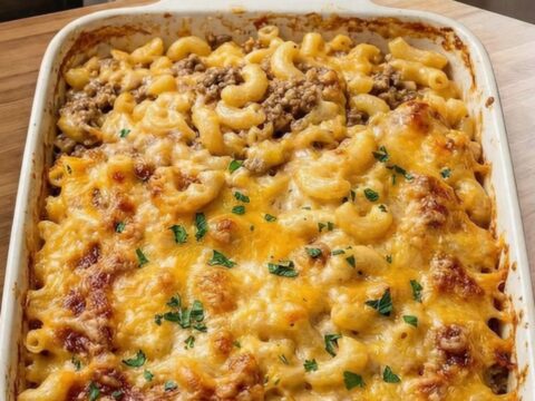 A steaming slice of mac and cheese meatloaf casserole on a white plate.