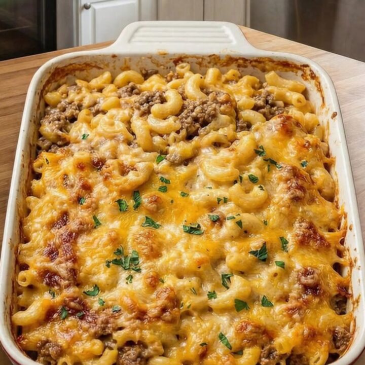 A steaming slice of mac and cheese meatloaf casserole on a white plate.