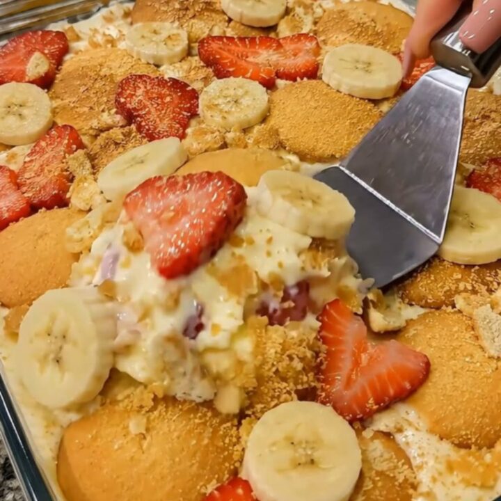 A glass dish filled with layers of creamy vanilla pudding, sliced bananas, fresh strawberries, and vanilla wafers.