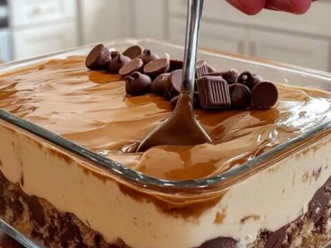 A close-up shot of a layered chocolate caramel cream dessert in a clear glass dish.