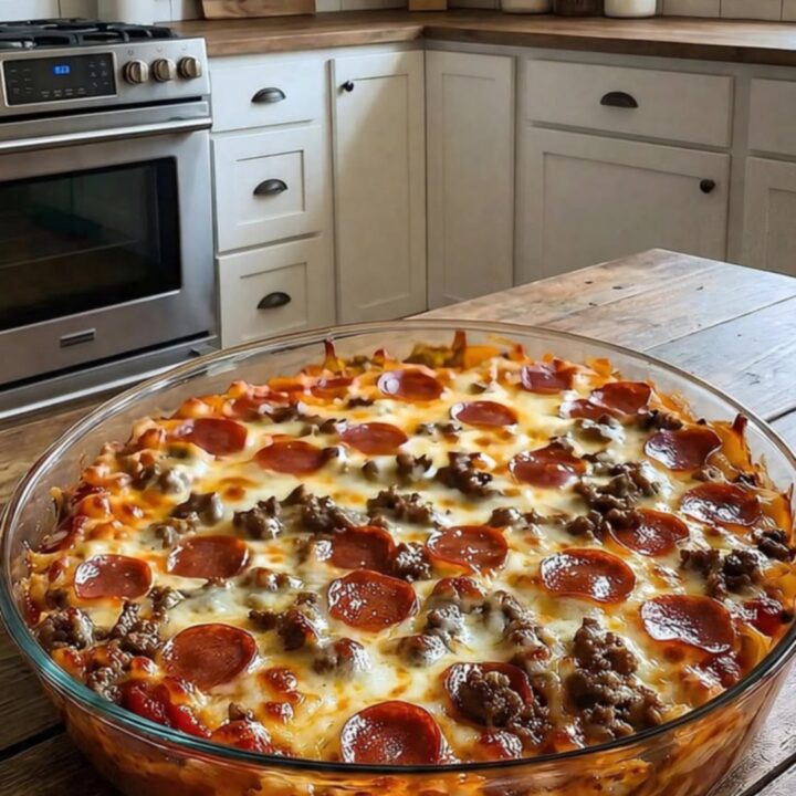 A steaming meat lovers pizza casserole in a glass dish with melted mozzarella and pepperoni.