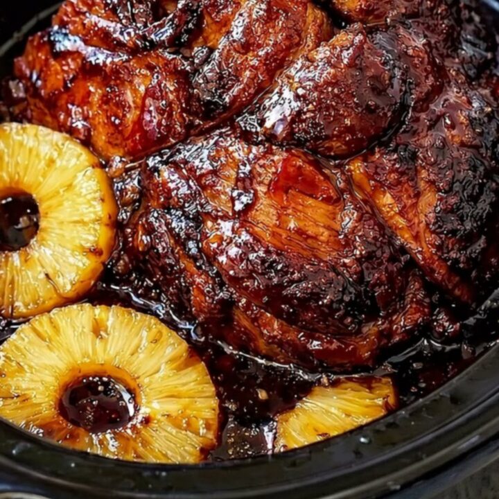 A succulent, slow-cooked beef roast glistening with a rich, caramelized glaze and surrounded by sweet pineapple slices