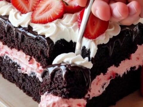 A slice of decadent chocolate strawberry sheet cake on a white plate showing layers.