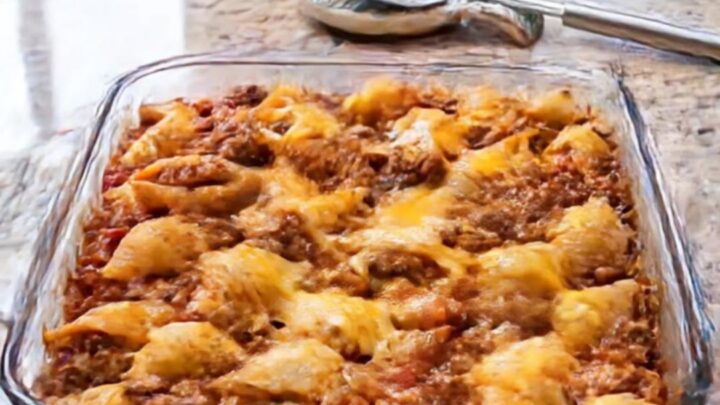 A warm, golden-brown cheesy beef pasta shells casserole in a glass baking dish.