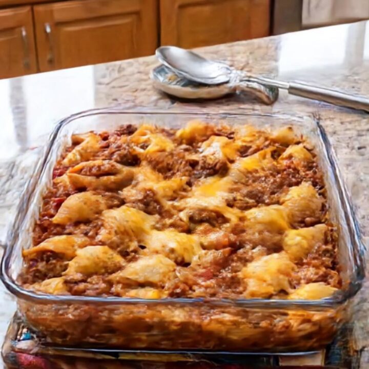 A warm, golden-brown cheesy beef pasta shells casserole in a glass baking dish.