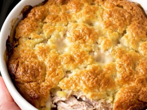A top-down view of a slow cooker filled with chicken, vegetables, and a creamy herb sauce.
