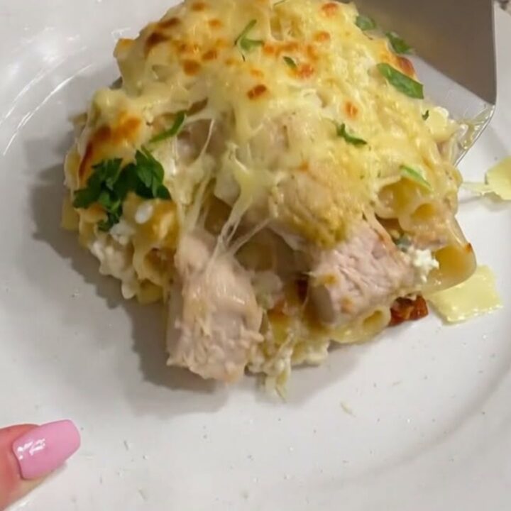 A golden-brown, bubbling Chicken Alfredo Lasagna in a baking dish with melted mozzarella cheese.