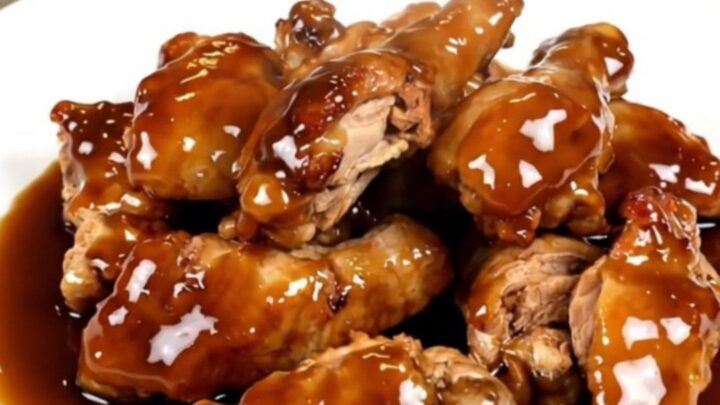 Slow cooker filled with cubed chicken breasts, pineapple chunks, brown sugar, and teriyaki sauce before cooking.