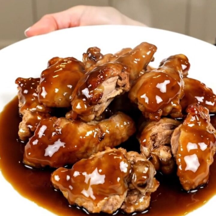Slow cooker filled with cubed chicken breasts, pineapple chunks, brown sugar, and teriyaki sauce before cooking.