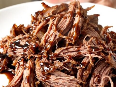 A succulent balsamic glazed pot roast plated on a white dish with a glossy finish.