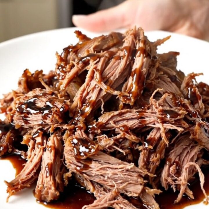 A succulent balsamic glazed pot roast plated on a white dish with a glossy finish.