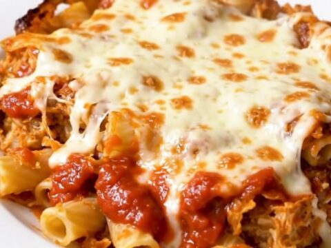A steaming bowl of baked ziti with melted mozzarella cheese and savory Italian sausage crumbles.