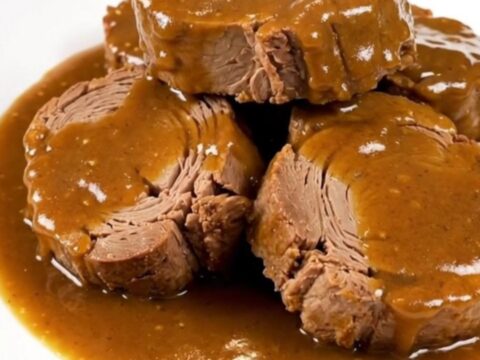 A succulent, slow-cooked pork roast topped with caramelized onions and a glossy, rich brown sugar Dijon sauce.