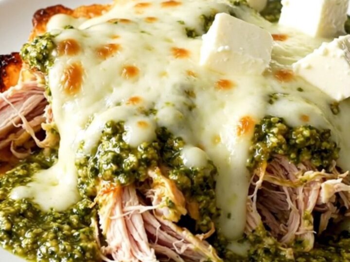 Creamy pesto mozzarella chicken in a slow cooker with vibrant cherry tomatoes.