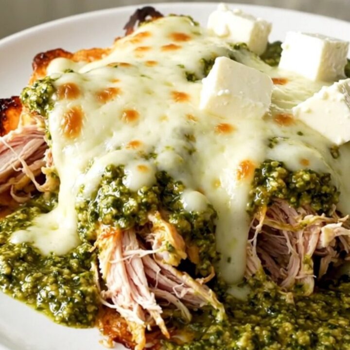 Creamy pesto mozzarella chicken in a slow cooker with vibrant cherry tomatoes.