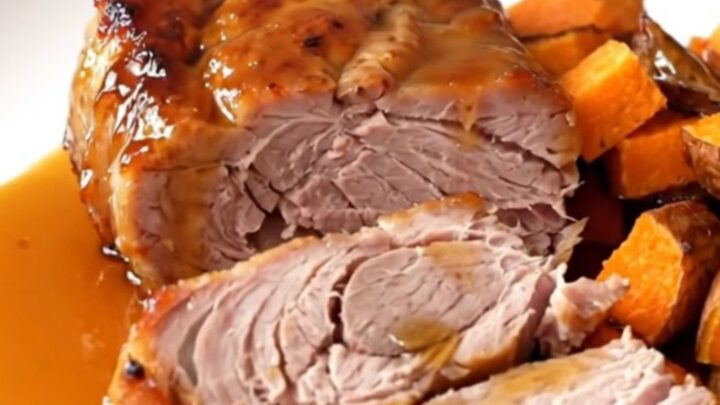 A close-up of glazed pork tenderloin and sweet potatoes served on a white plate.