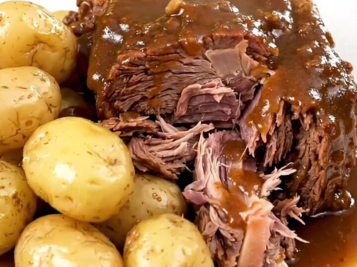 A succulent beef chuck roast served with tender gold potatoes in a slow cooker, looking warm and inviting.