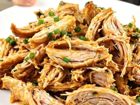 A plate of creamy, shredded Mexican street corn chicken showing tender meat and corn kernels.