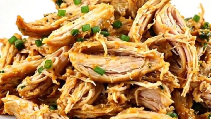 A plate of creamy, shredded Mexican street corn chicken showing tender meat and corn kernels.