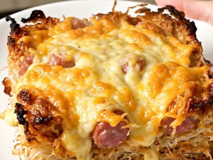 A close-up of a cheesy smoked sausage and hash brown casserole in a slow cooker.