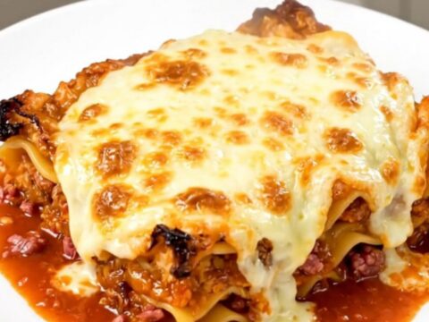 A steaming, hearty meat lasagna in a slow cooker with rich red sauce and tender noodles.