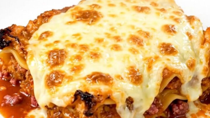 A steaming, hearty meat lasagna in a slow cooker with rich red sauce and tender noodles.