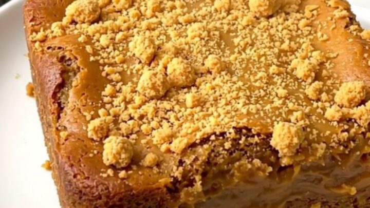 A warm, golden-brown pumpkin butterscotch dump cake served on a simple white plate.