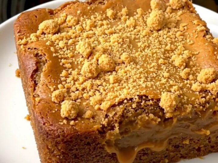 A warm, golden-brown pumpkin butterscotch dump cake served on a simple white plate.