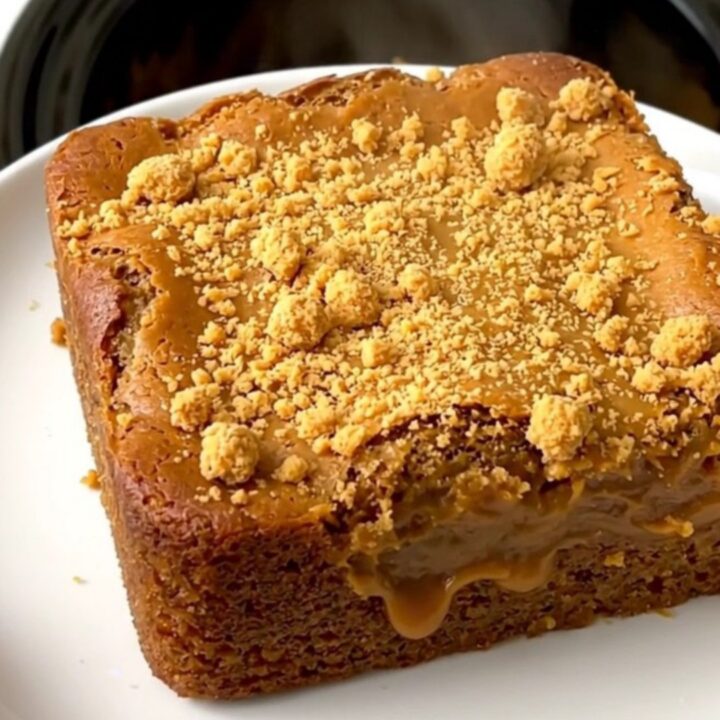 A warm, golden-brown pumpkin butterscotch dump cake served on a simple white plate.