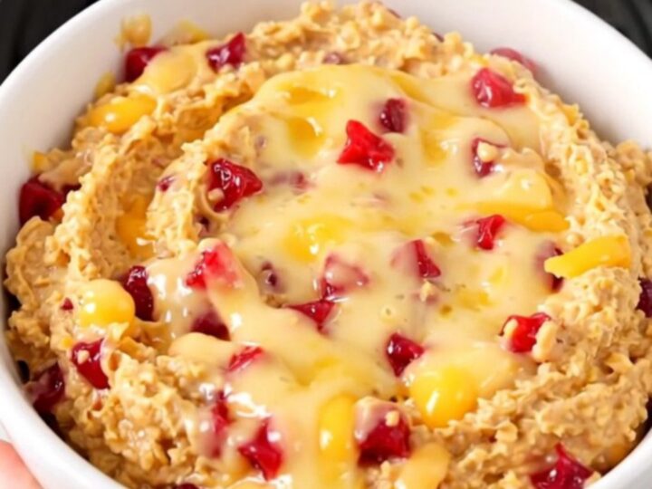 A warm, creamy pimento cheese dip served in a white bowl on a bright kitchen counter.