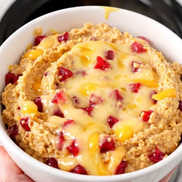 A warm, creamy pimento cheese dip served in a white bowl on a bright kitchen counter.