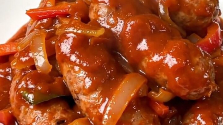 Finished slow cooker Italian sausage and pepper filling served on a white plate.