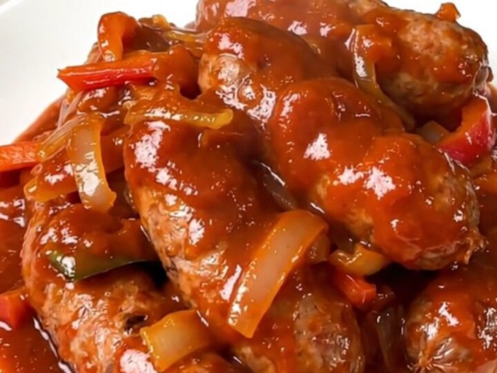 Finished slow cooker Italian sausage and pepper filling served on a white plate.