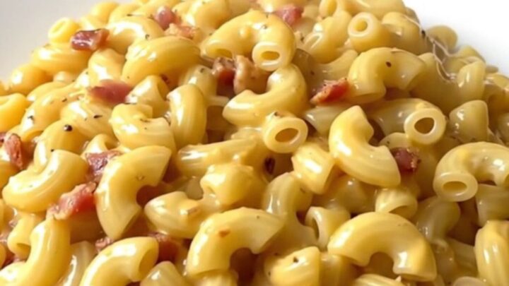 A creamy bowl of slow cooker macaroni topped with crumbled bacon.