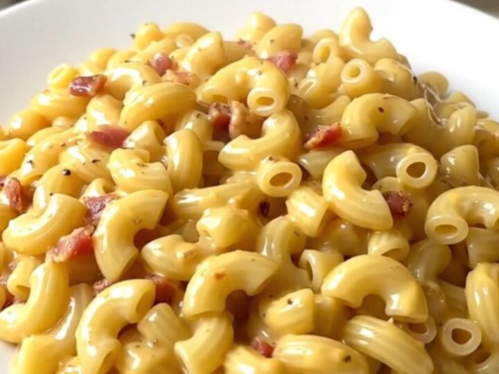 A creamy bowl of slow cooker macaroni topped with crumbled bacon.