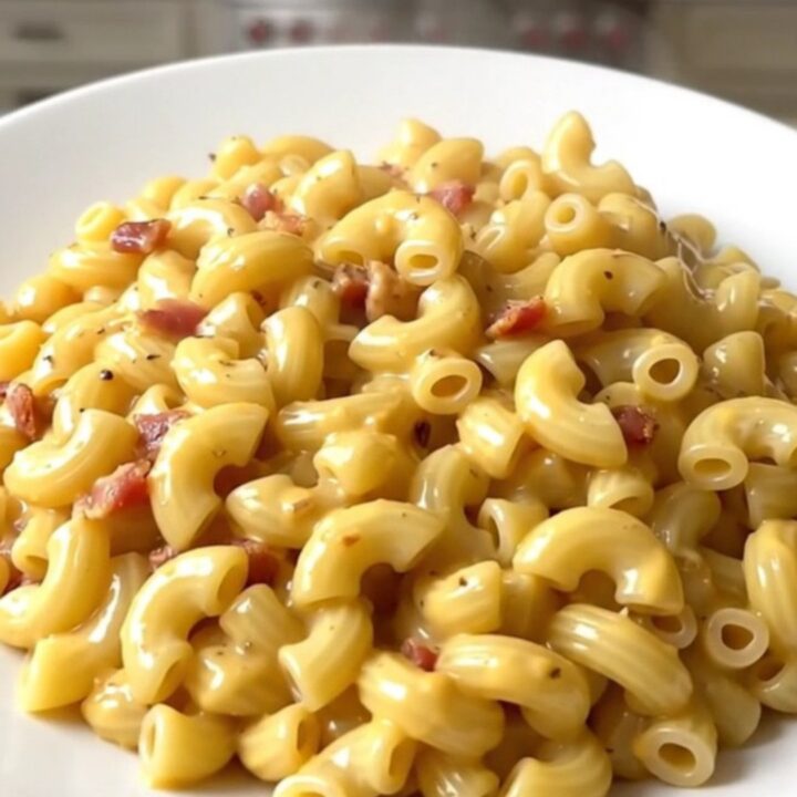 A creamy bowl of slow cooker macaroni topped with crumbled bacon.
