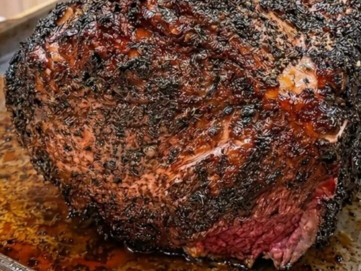 A magnificent prime rib roast with four frenched bones and a deep, crispy garlic-herb butter crust.