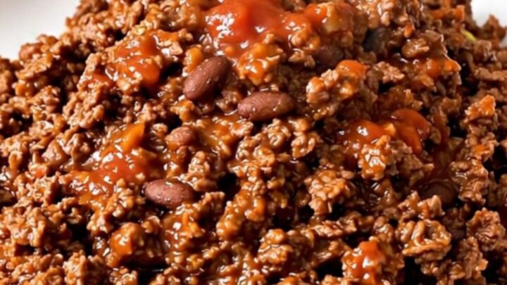 A steaming, glossy portion of ground beef burrito filling served on a plain white plate.