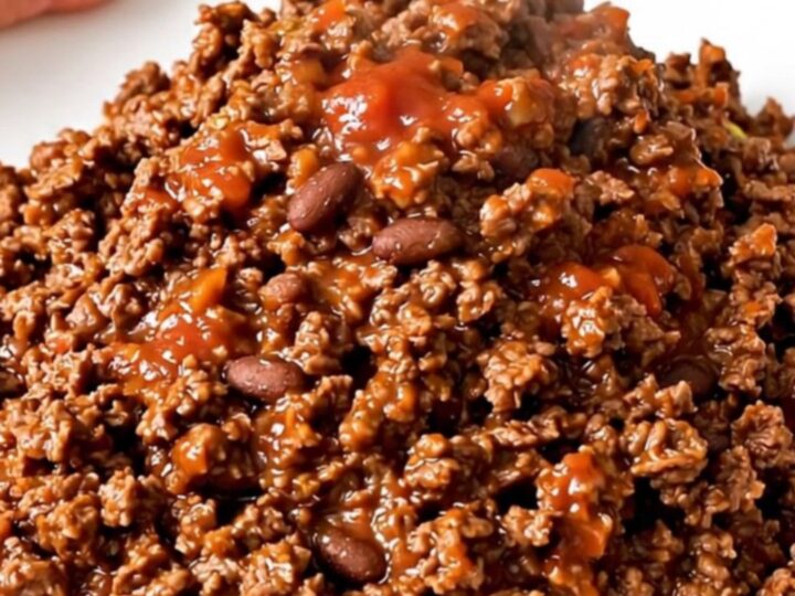 A steaming, glossy portion of ground beef burrito filling served on a plain white plate.