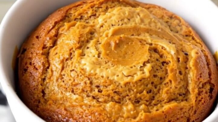 A close-up view of the finished pumpkin cream cheese swirl cake in a white bowl showing the moist texture.