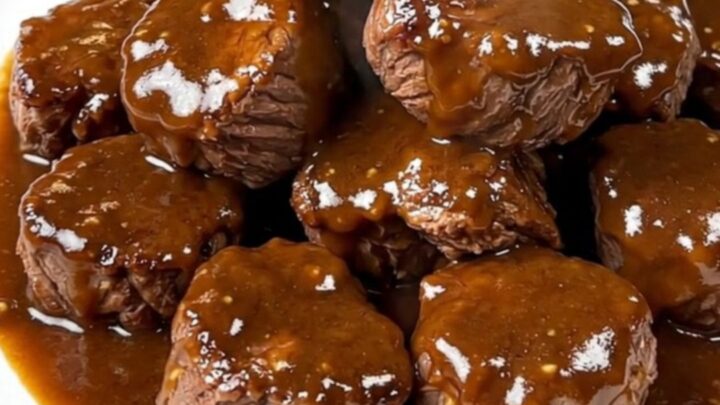 A close-up of tender, glossy brown sugar Dijon steak bites served on a white plate.