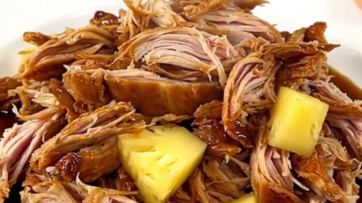 Slow-cooked shredded teriyaki turkey served with pineapple chunks on a white plate.