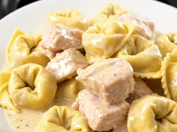 A steaming, creamy bowl of slow cooker chicken and cheese tortellini in a rich alfredo sauce.