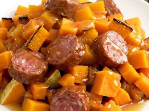 A finished slow cooker smoked sausage and butternut squash bake served on a white plate.